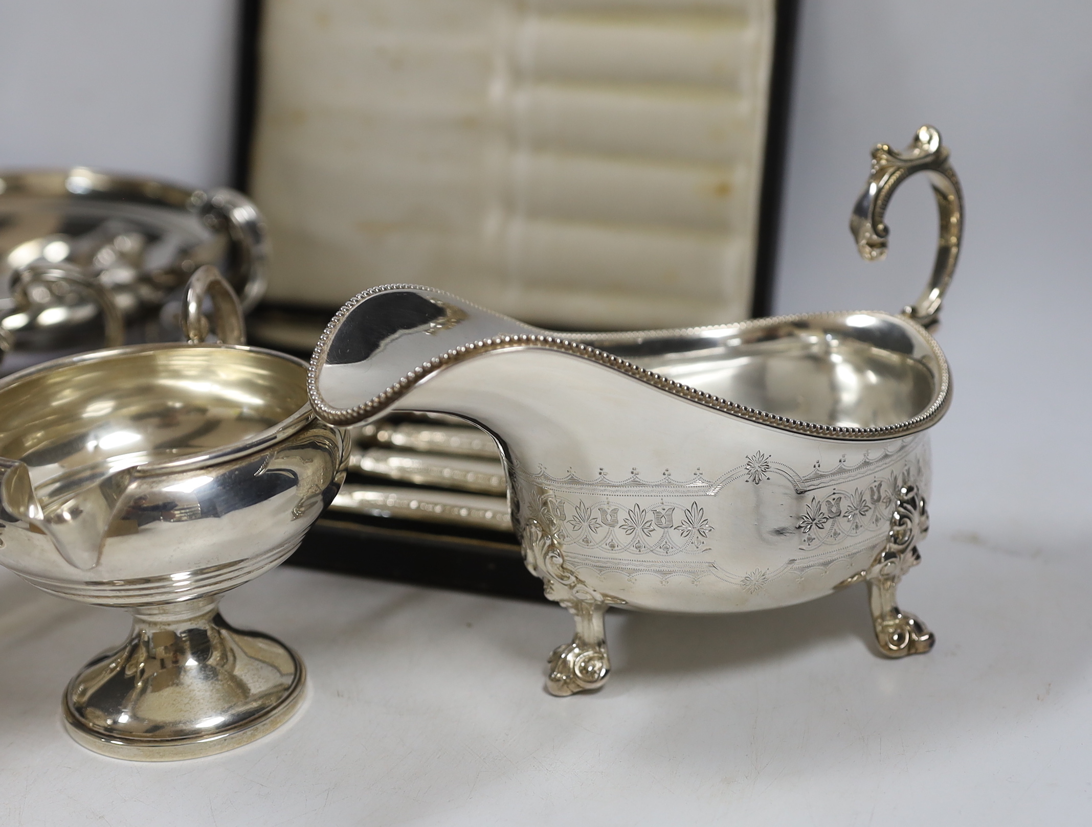 A small collection of silver including a sauceboat, two handled shallow bowl, five teaspoons and a commemorative spoon, together with a sterling cream jug and sugar bowl, sterling flatware and set of four pepperettes, to